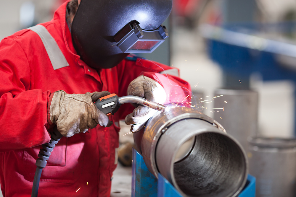 Welder with protective mask welding metal and sparks