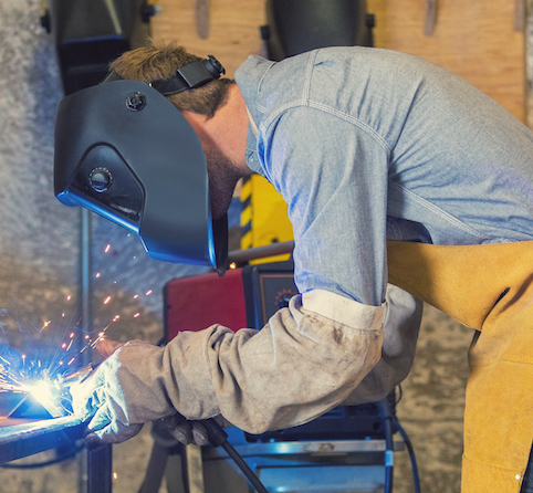Professional welder using metal torch in workshop